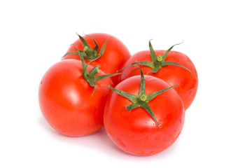 vier saftige frische rote Tomaten liegen freigestellt auf weißem Hintergrund