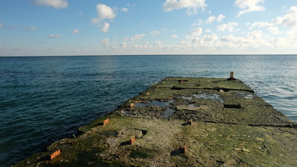 An old concrete pier near a calm sea.