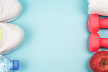 Sports shoes, dumbbell fitness in the blue background. Different sports tools