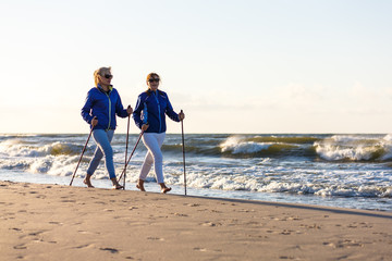 Nordic walking - active people working on beach