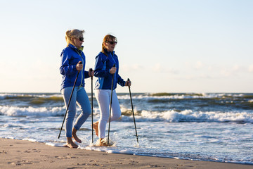 Nordic walking - active people working on beach