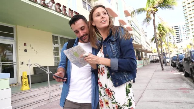 Young couple looking at tourist map in Miami