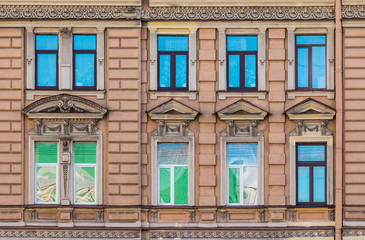 Fototapeta na wymiar Several windows in a row on the facade of the urban historic building front view, Saint Petersburg, Russia 
