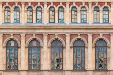 Many windows in a row on the facade of the urban historic building front view, Saint Petersburg, Russia
