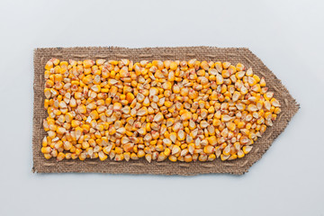 Arrow made of burlap with corn grains.