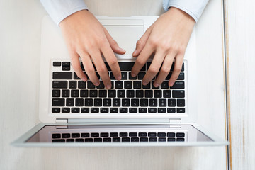 Fototapeta na wymiar Woman hands typing on laptop computer close-up