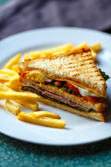 Delicious club sandwich with french fries at a diner.