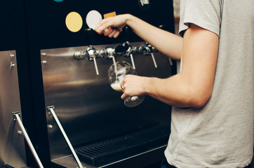 in the bar, a barman picks up a light beer in a glass. party at the bar. low alcohol beverages