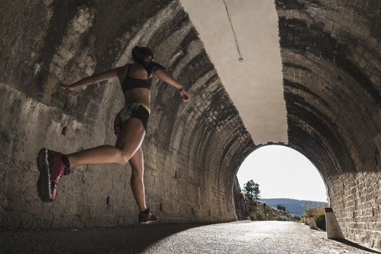 Strong woman in tunnel runing and training exercises