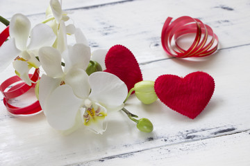 White orchid flowers and red hearts on white wooden board.Valentine's day,romantic background