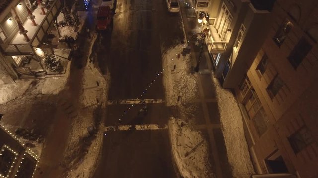 Aerial shot of people in small mountain town at night at christmas