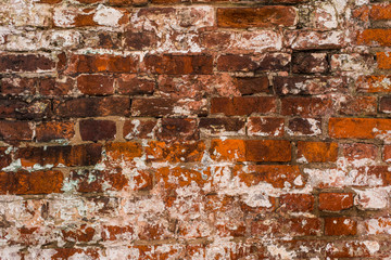 Ancient brick wall with remains of plaster - grunge background, texture