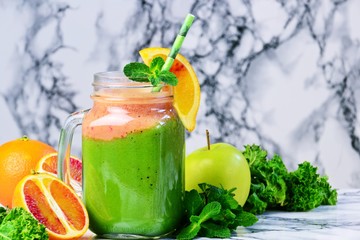 Fresh Green Smoothies with blood oranges. Green smoothie jar on the light background
