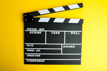 Fototapeta na wymiar Cinema minimal concept. Watching film in the cinema. clapper board on yellow background. Screenwrite desktop