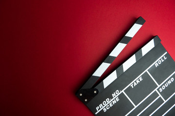 Cinema minimal concept. Watching film in the cinema. clapper board on red background. Screenwrite desktop