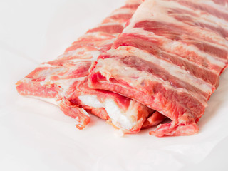 raw pork ribs on white parchment paper, side view