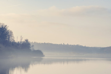 Fototapeta premium Lake scenery with morning fog and silent water