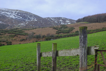 Fototapeta na wymiar A view across on of the many snow topped hills and valleys of the Mourne Mountains on a dull midwinter afternoon 