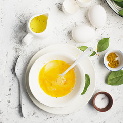 Ingredients for scrambled eggs with spinach and turmeric on the background. Top view. Copy space.