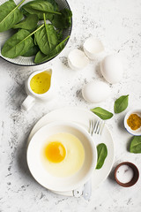 Ingredients for scrambled eggs with spinach and turmeric on the background. Top view. Copy space.