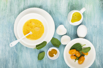 Ingredients for scrambled eggs with spinach and turmeric on the background. Top view. Copy space.