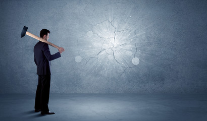 Obraz premium Business man hitting wall with a hammer