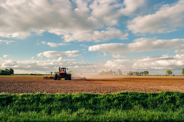 Farmer tilling land with tractor on farm in country