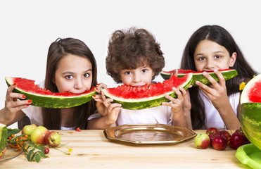 Cute kids eating watermelon over gray background