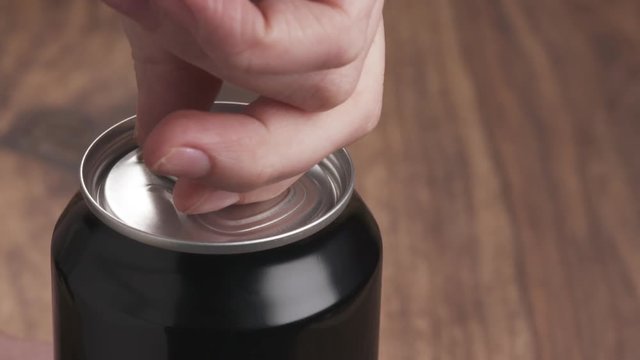 Slow motion young female hand tries to open can