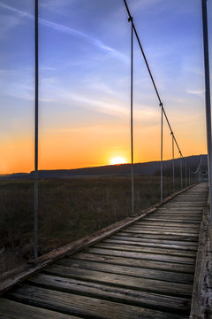 A Wooden Rope Bridge At Sunset