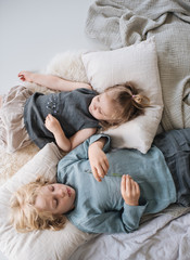 geschwister liegen zuhause in ihrem Kinderzimmer nebeneinander