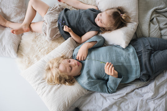 geschwister liegen zuhause in ihrem Kinderzimmer nebeneinander