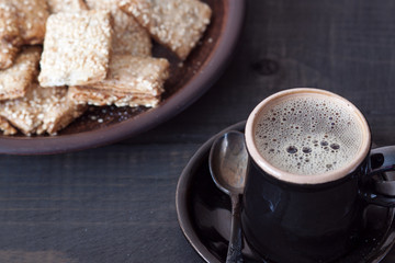 Cup of hot coffee and cookies for breakfast on wooden table