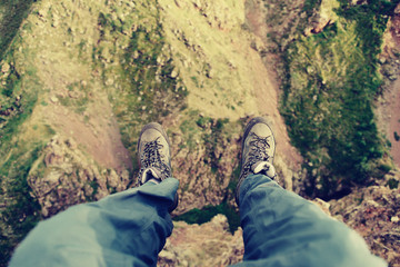 Male hiker sitting on edge of cliff.