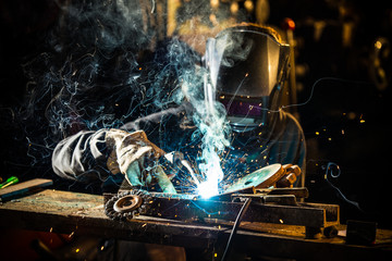 Welder working at the factory made metal