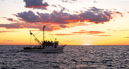 Obraz premium Small ship in sea. Summer day sunset.