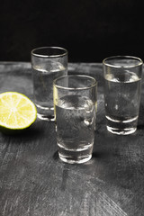 Cold vodka in shot glasses on a black background
