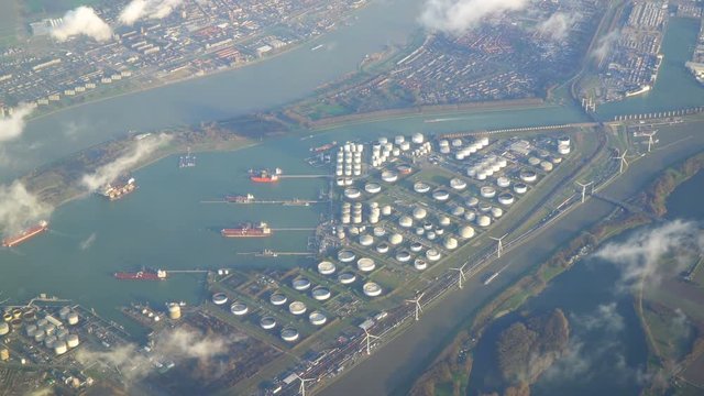 Flying over Rotterdam, Netherlands, numerous silos, boats, wind turbines and industrial sites in view