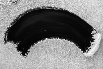 Worn fragment of white artificial snow on a black background