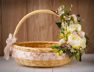 Fototapeta na wymiar Festive basket decorated with flowers on wooden background.