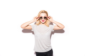 Photo of excited young blonde woman wearing sunglasses standing isolated over white background.