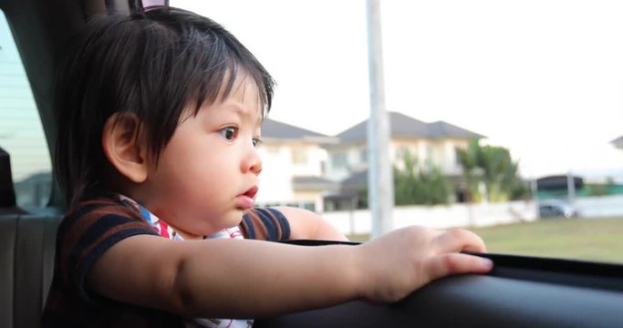 baby boy looking out of window car move driving from house
