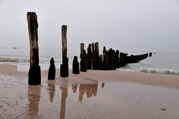 old wooden breakwater on the baltic beach after the season
