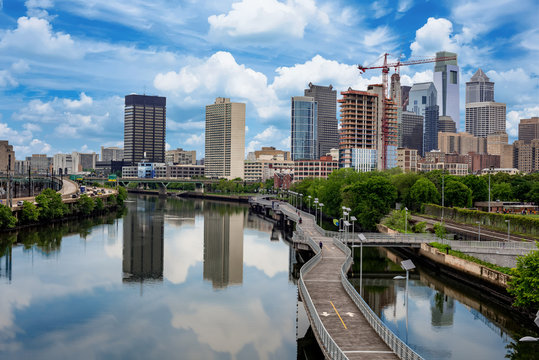 Philadelphia Pennsylvania skyline with walking path along river and clouds