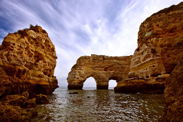 Ocean beaches of Portugal. Sand and waves on a bright summer day. City of Algarve and Faro