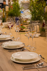 Table in the restaurant served for several persons with glasses and plates, cozy