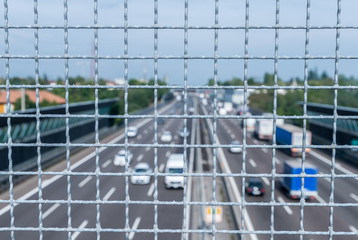 Narrow depth of field looking down from railing onto busy freeway