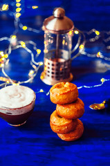 pyramid of cookies. a cup of coffee with milk. garland. blue background. morning breakfast