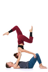 Young athletic couple practicing acroyoga. Balancing in pair