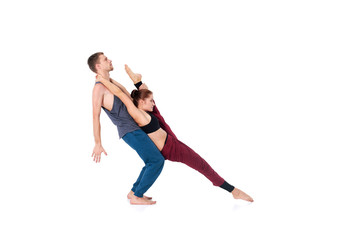 Young athletic couple practicing acroyoga. Balancing in pair
